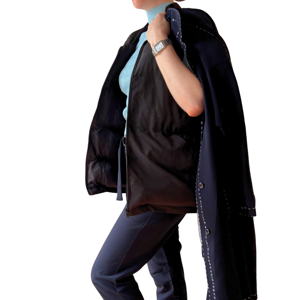 Model wearing the Cabin Vest travel vest with a navy coat over her shoulder