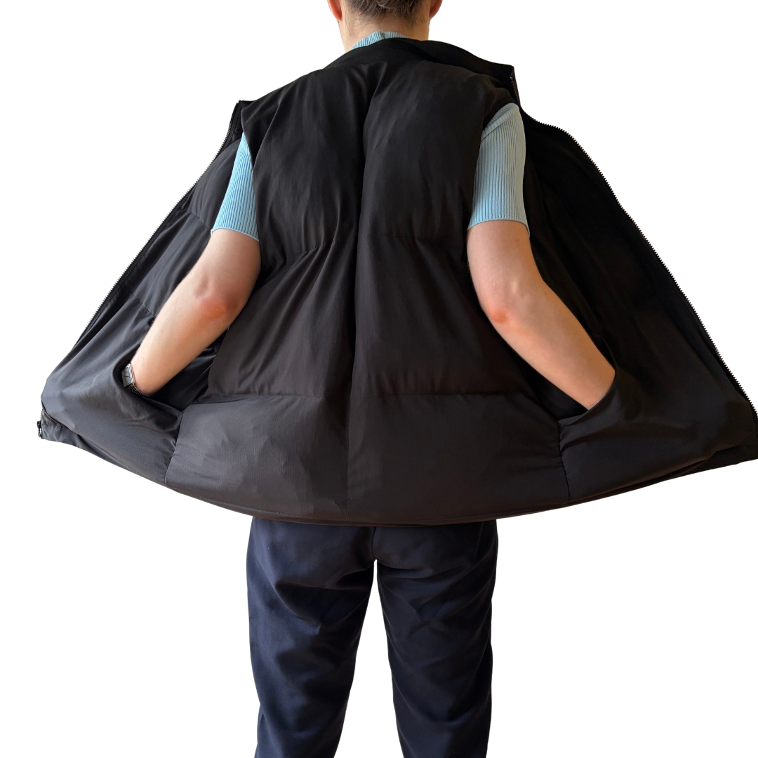Back view of model holding the Cabin Vest open, showing the inner lining