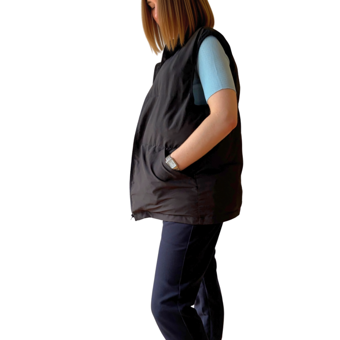 Side view of woman wearing the black Cabin Vest travel vest, hand in pocket