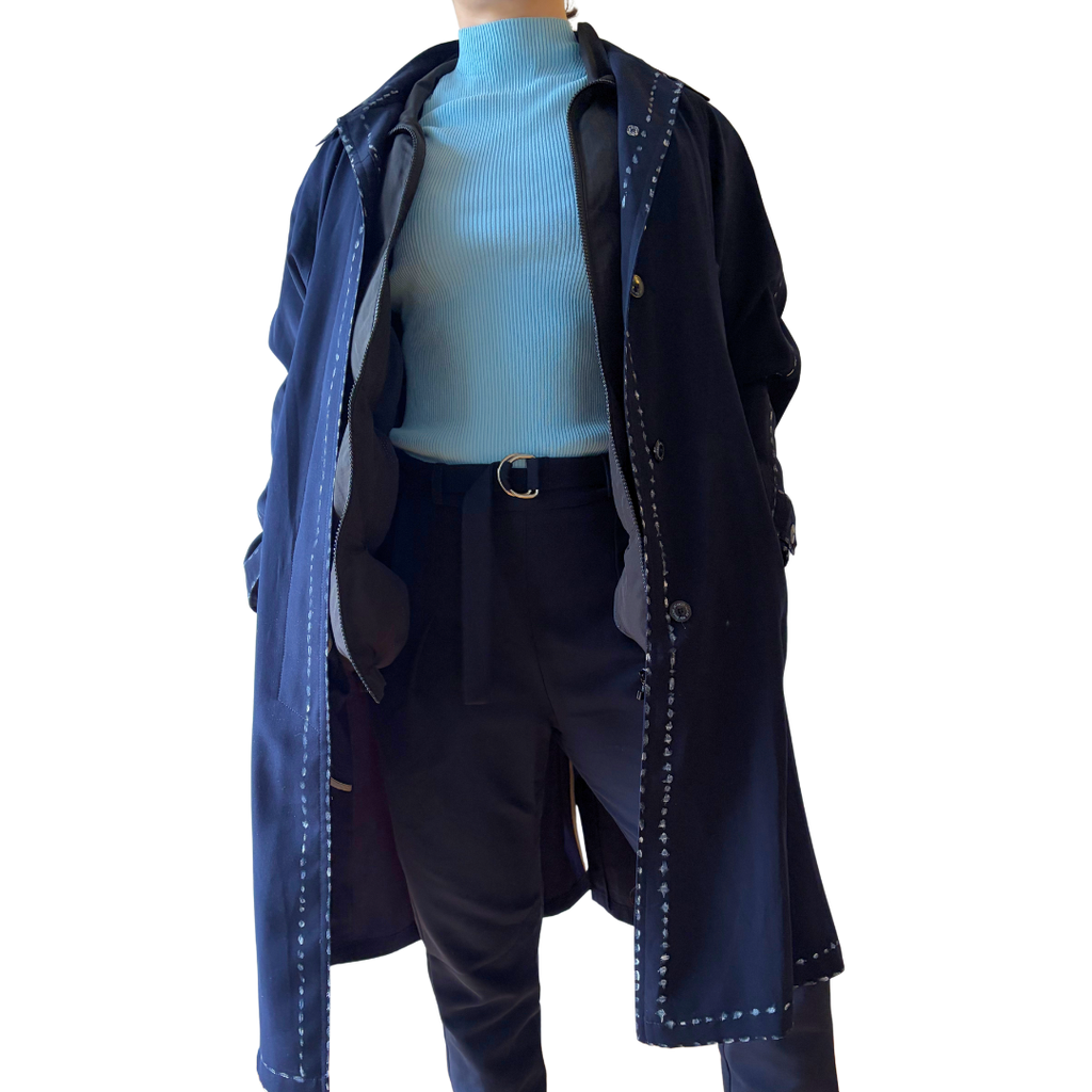 Model wearing the Cabin Vest hidden under an open navy coat, ready to board